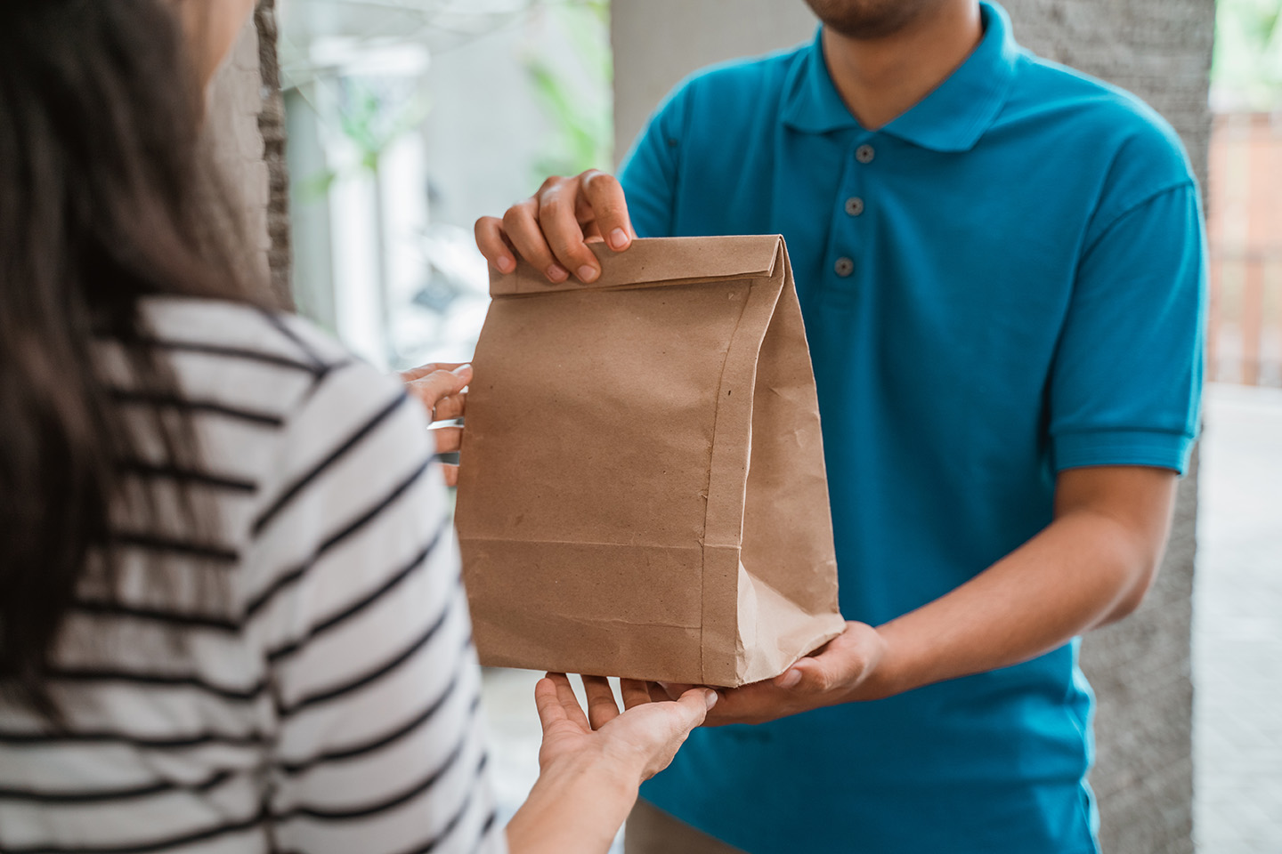 Delivery man delivering food to woman at home Good food eating